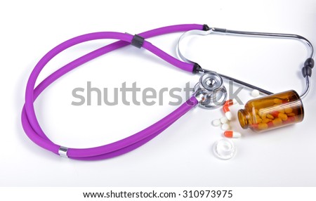 medical stethoscope with pills isolated on white background
