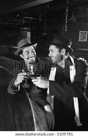Caucasian prime adult retro males sitting at bar drinking.
