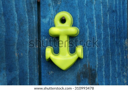anchor that kept the ship in port  on a blue rustic wooden background