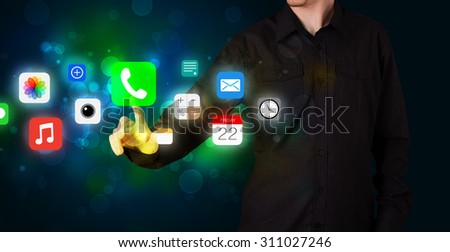 Businessman pressing colorful mobile app icons with bokeh background
