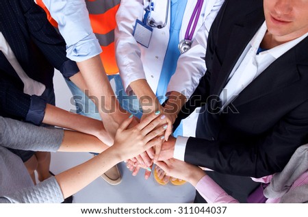 Portrait of people with various occupations putting their hands on top of each other Royalty-Free Stock Photo #311044037