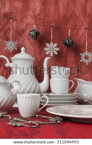 Christmas decoration table display in simple and elegant style. White crockery over red background