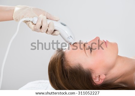 Young Woman Receiving Laser Hair Removal Treatment At Beauty Center Royalty-Free Stock Photo #311052227