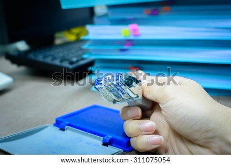 Accessory in business office, Date months years stamper in male's hand on desk