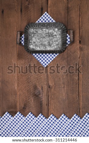 Old wooden background with blue and white checked border for bavarian decorations.