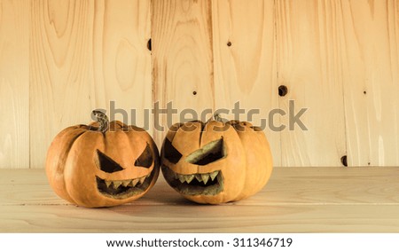 vintage color tone image of Halloween pumpkins with a Jack 'O Lantern on wooden background.