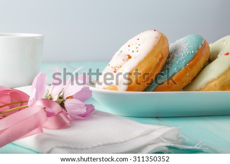 Four donuts on old wood table with flowers