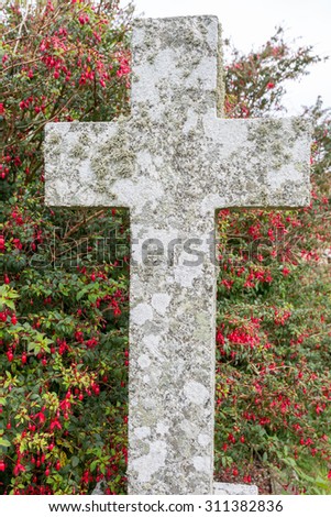 Cross with fuscia flowers in the background