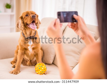 Young woman is making a picture with her cute dog pet.