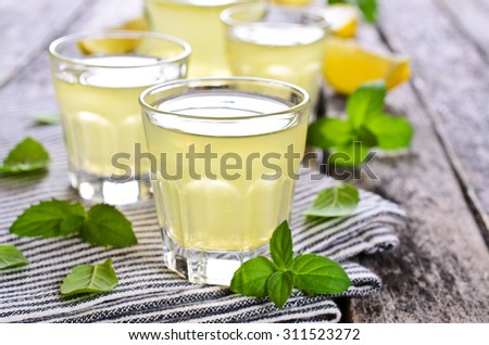 Drink of lemon in a small glass on a wooden surface