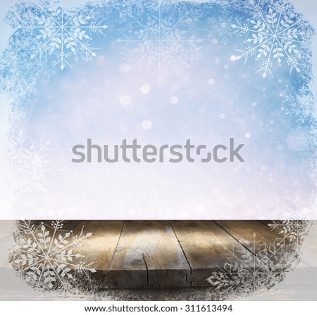 rustic wood table in front of glitter silver and white bright bokeh lights  with snowflakes overlay
