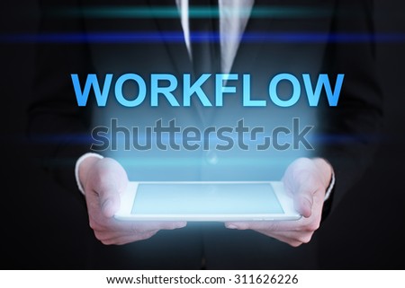 Businessman holding a tablet pc with "Workflow" text on virtual screen. Internet concept. Business concept.