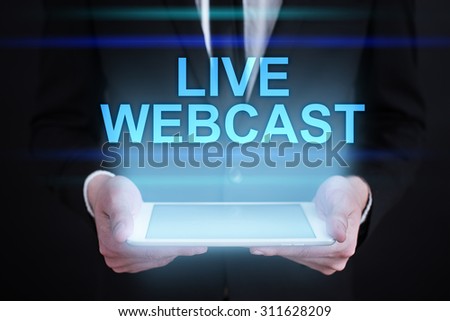 Businessman holding a tablet pc with "Live webcast" text on virtual screen. Internet concept. Business concept. 