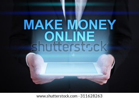 Businessman holding a tablet pc with "Make money online" text on virtual screen. Internet concept. Business concept. 
