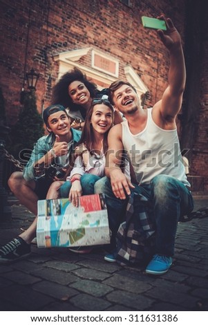 Multiracial friends tourists making selfie in an old city 