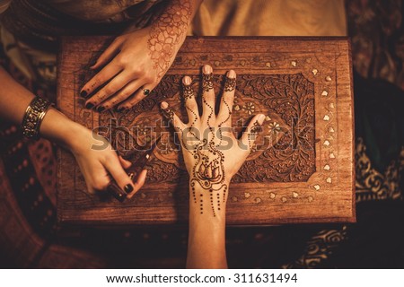 Drawing process of henna menhdi ornament on woman's hand  Royalty-Free Stock Photo #311631494