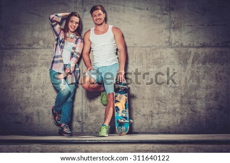 Young couple with skateboard  outdoors 