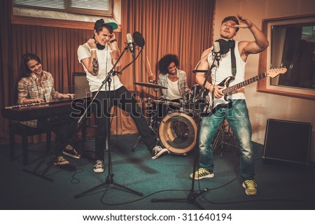 Multiracial music band performing in a recording studio 