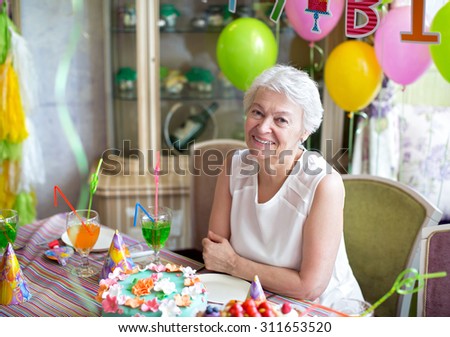 Smiling elderly woman at a birthday party