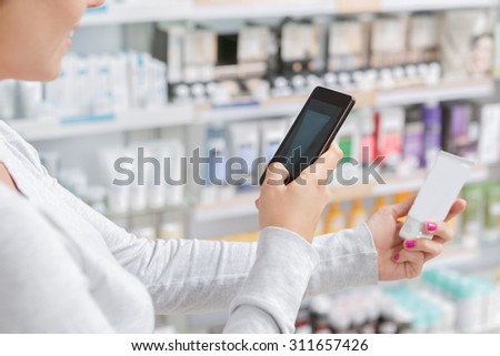 Close up of a woman taking picture of the product in drugstore