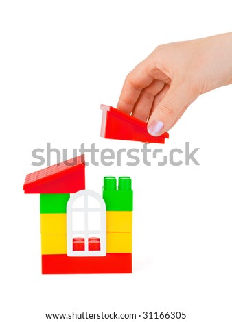 Hand and toy house isolated on white background