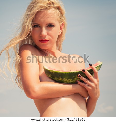 young beautiful slender girl , attractive blonde, enjoys tropical hot weather, eats  fresh, aromatic a water-melon, wind develops beautiful long hair, slim tanned body,  thin nose. instagram 