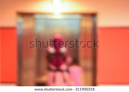 Blur image of woman carrying her son with her daughter 