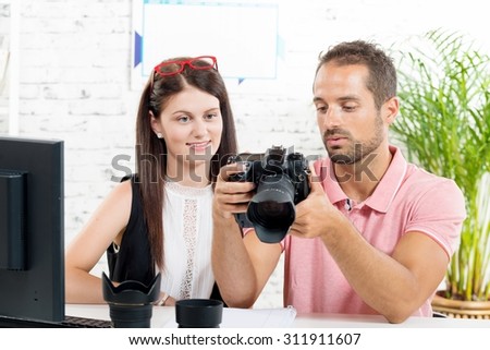 a young couple looking at pictures on camera