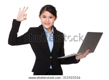 Businesswoman hold laptop computer and with ok sign gesture