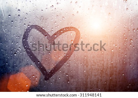 Autumn rain, the inscription on the sweaty glass - love and heart Royalty-Free Stock Photo #311948141