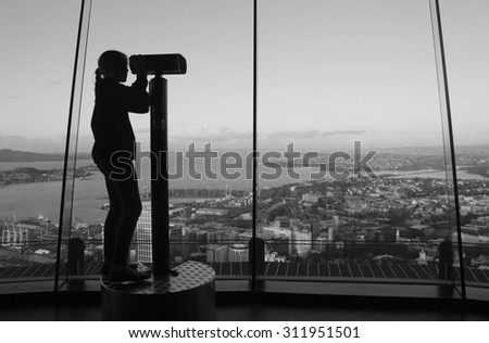 a little girl looking through a coin operated binoculars at the 