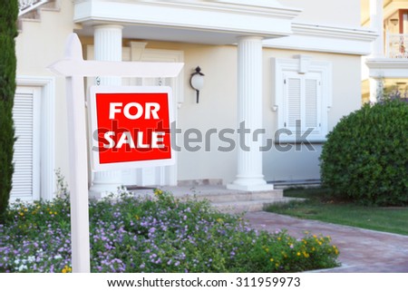 Real estate sign in front of new house for sale