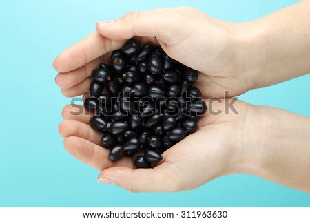 currants and hands on blue background