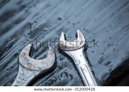 spanner tool with dew drop on top of  wooden table