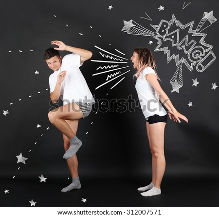 Young woman screaming against young man, on black background