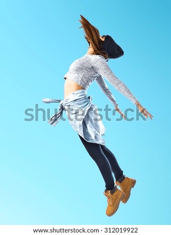 Girl jumping in hip hop style over colorful background