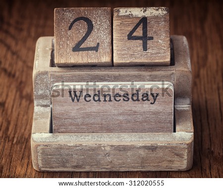 Grunge calendar showing Wednesday the twenty fourth  on wood background