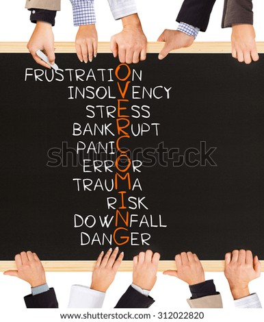Photo of business hands holding blackboard and writing OVERCOMING concept