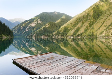 Mountain with pine trees reflected in a lake