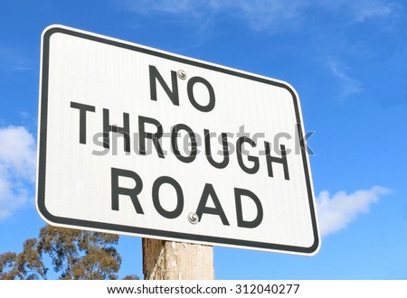A black and white 'No Through Road' sign against a blue sky