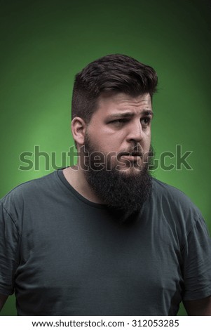 Confused man portrait, looking to right side. Green screen background.
