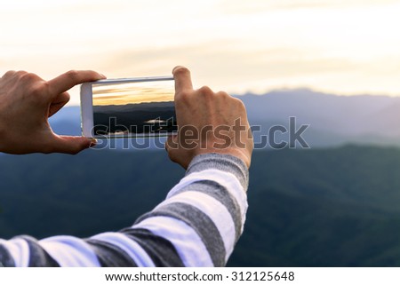 Man using smart phone take a photo mountain view