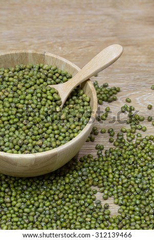 Green bean seed in a wooden bowl on wooden table
