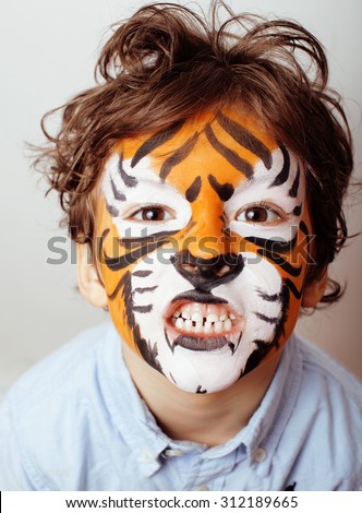 little cute boy with faceart on birthday party close up, orange tiger