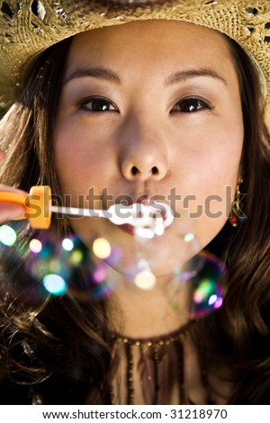 A beautiful asian girl playing with bubbles outdoor during summer