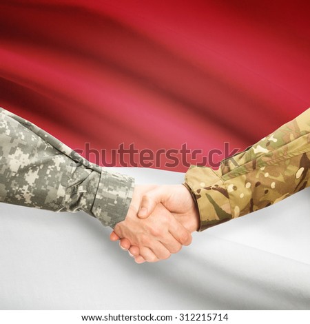 Soldiers shaking hands with flag on background - Monaco