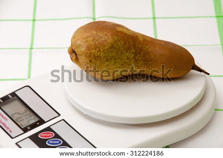 Pear on a white kitchen digital scale.