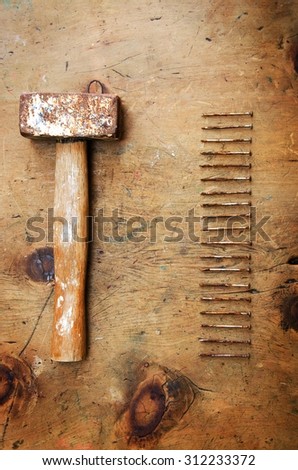 Old wood table with hammer and nails in rustic vintage style. Top view. Retro concept background.
