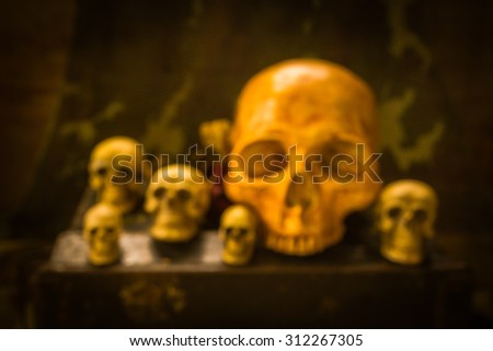 Abstract blur still life with group of skull on bullet box
