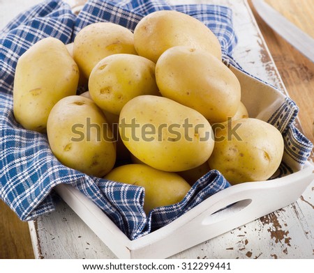 Fresh potatoes on wooden background. Selective focus